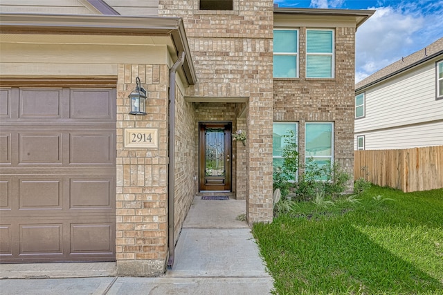 doorway to property featuring a lawn and a garage