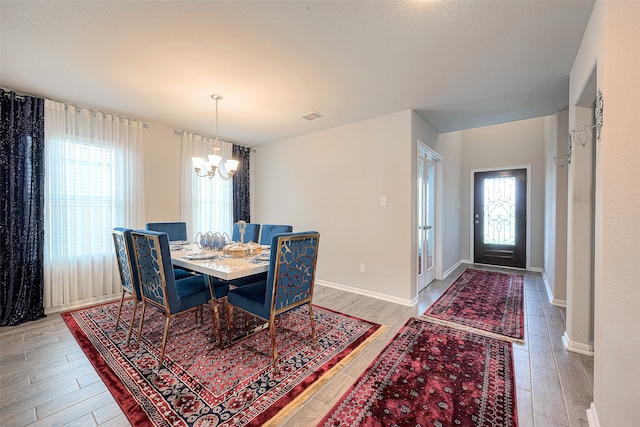 dining room with light hardwood / wood-style flooring and a notable chandelier