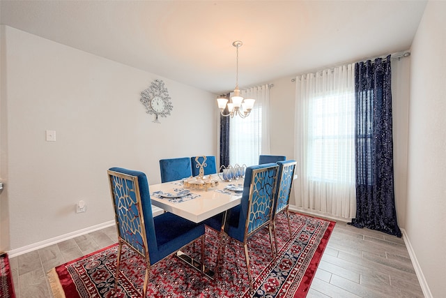 dining space with an inviting chandelier and light hardwood / wood-style floors