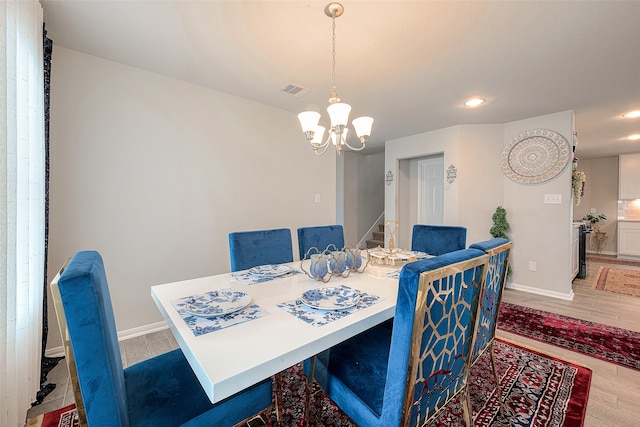 dining space with hardwood / wood-style floors and an inviting chandelier