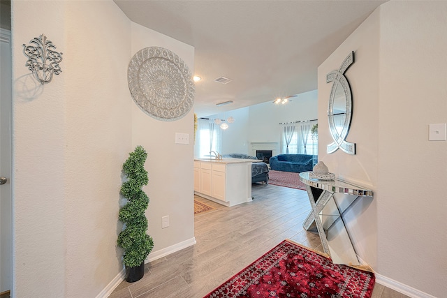 hallway featuring sink and light hardwood / wood-style floors