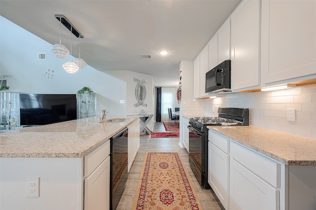 kitchen featuring black appliances, light hardwood / wood-style flooring, light stone counters, and sink