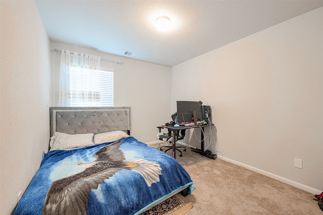 bedroom with a textured ceiling and light carpet