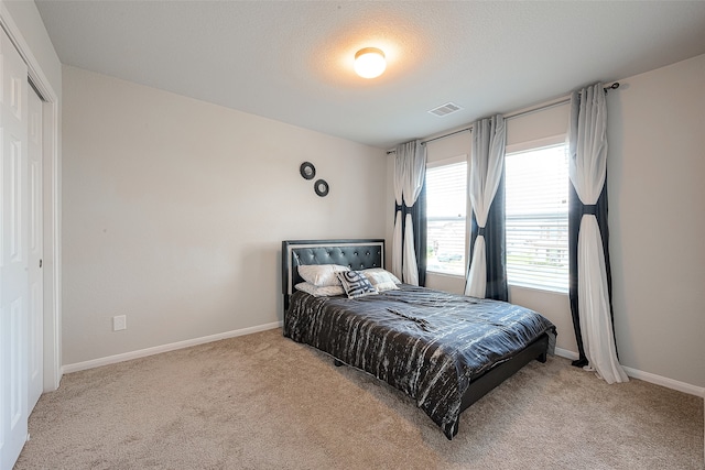 carpeted bedroom with a closet and a textured ceiling