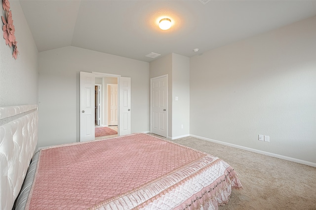 carpeted bedroom with lofted ceiling