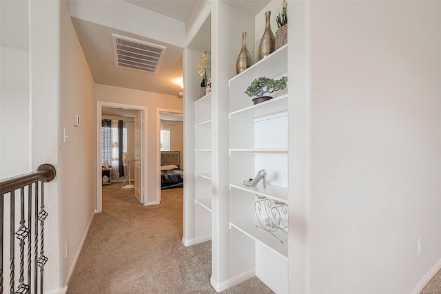 hallway featuring light colored carpet