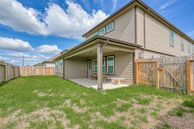 rear view of house with a lawn and a patio area