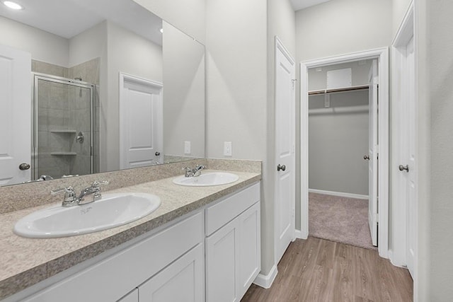 bathroom featuring vanity, hardwood / wood-style floors, and a shower with shower door