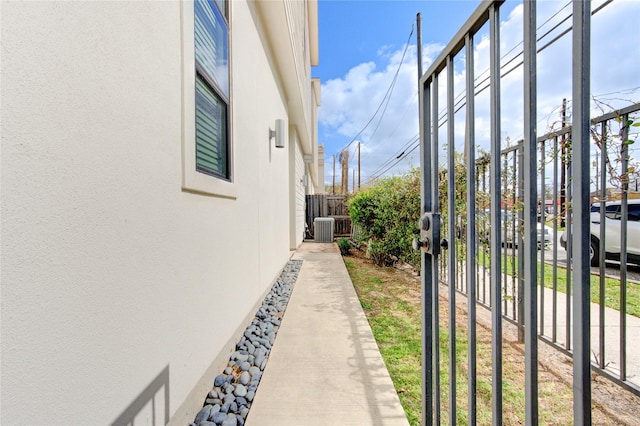 view of yard featuring central AC, fence, and a gate