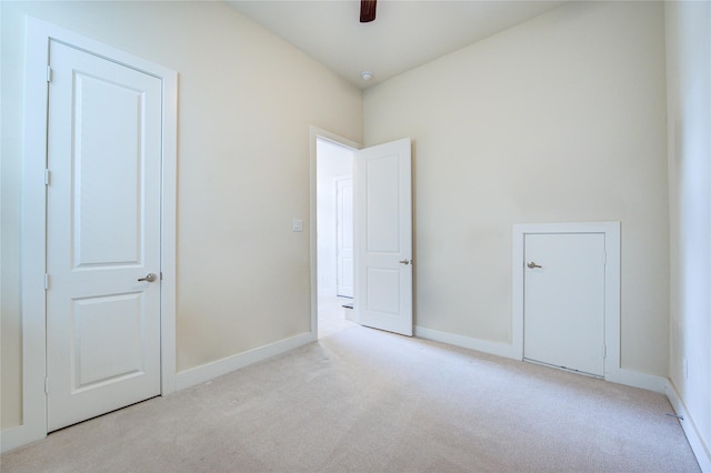 carpeted empty room featuring ceiling fan and baseboards