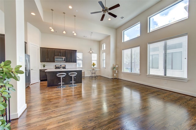 living room featuring dark wood-style floors, visible vents, and a high ceiling