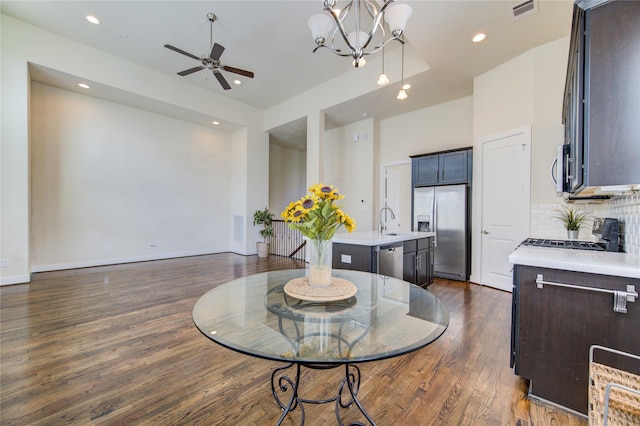 dining area featuring dark wood-type flooring, recessed lighting, visible vents, and ceiling fan with notable chandelier