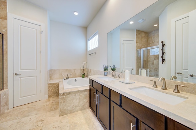 bathroom featuring double vanity, a garden tub, a sink, and a stall shower