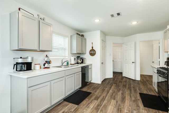 kitchen featuring black appliances, dark hardwood / wood-style flooring, and sink