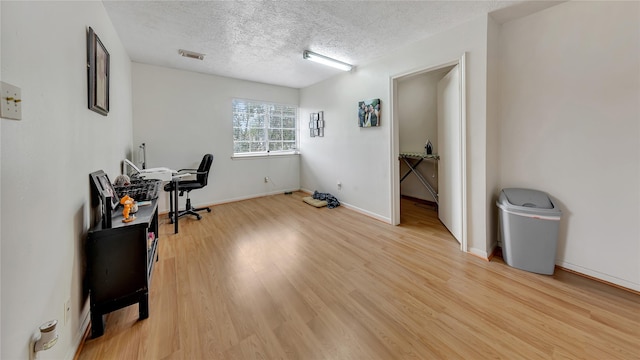 home office with wood-type flooring and a textured ceiling