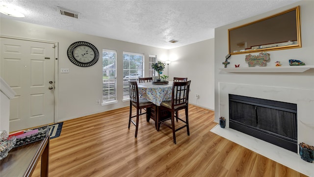 dining space featuring wood-type flooring and a textured ceiling