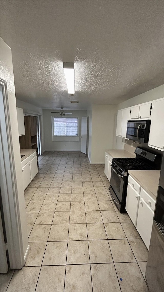 kitchen featuring appliances with stainless steel finishes, a textured ceiling, ceiling fan, white cabinets, and light tile patterned flooring