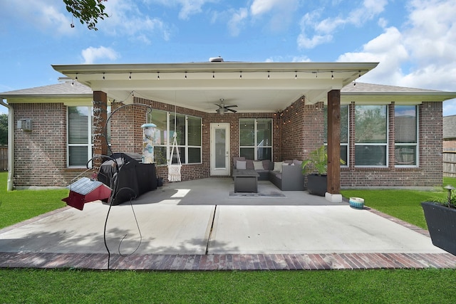 rear view of property with a yard, ceiling fan, and a patio