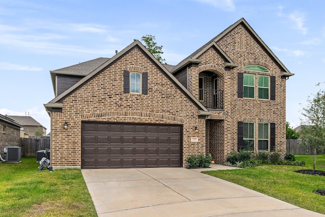 front of property with a garage, cooling unit, and a front lawn