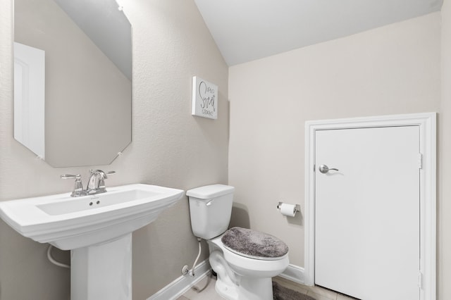 bathroom featuring toilet and lofted ceiling