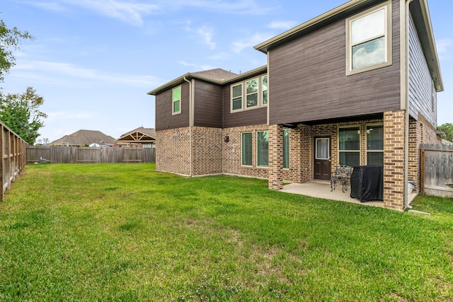 rear view of house featuring a patio and a yard