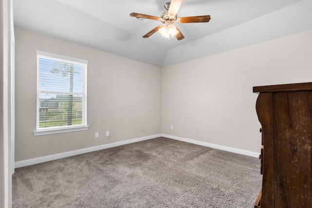 carpeted spare room with ceiling fan and vaulted ceiling