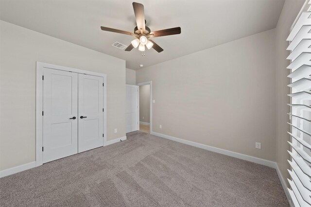 unfurnished bedroom featuring a closet, ceiling fan, and light carpet