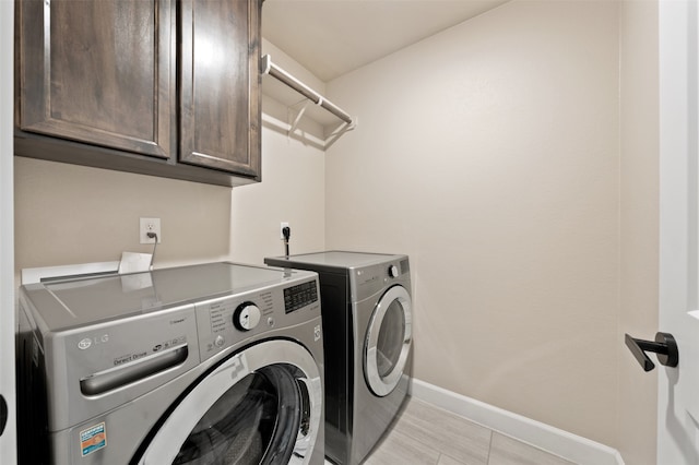 washroom with cabinets and washer and clothes dryer