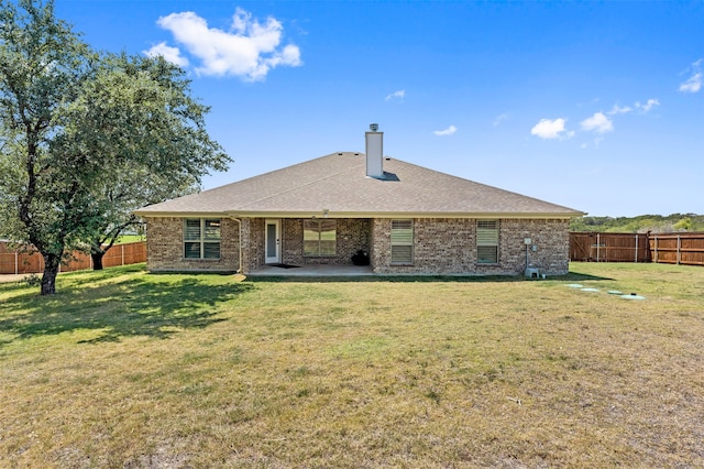 rear view of house with a yard and a patio