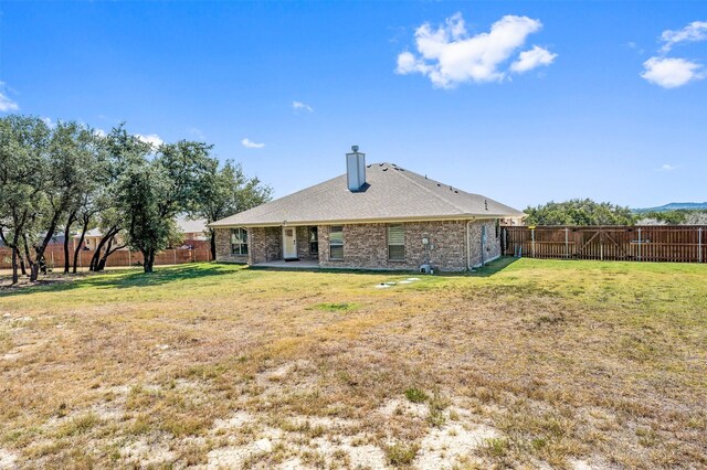 back of property with a yard and a patio