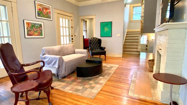 sitting room featuring a brick fireplace and light hardwood / wood-style flooring