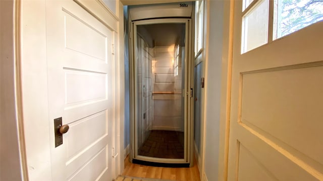 corridor with light hardwood / wood-style floors