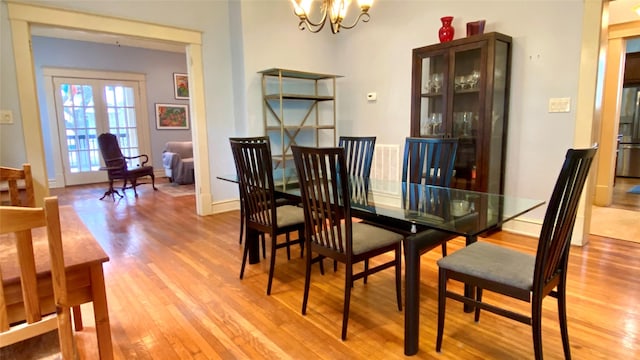 dining area with a notable chandelier and light hardwood / wood-style flooring