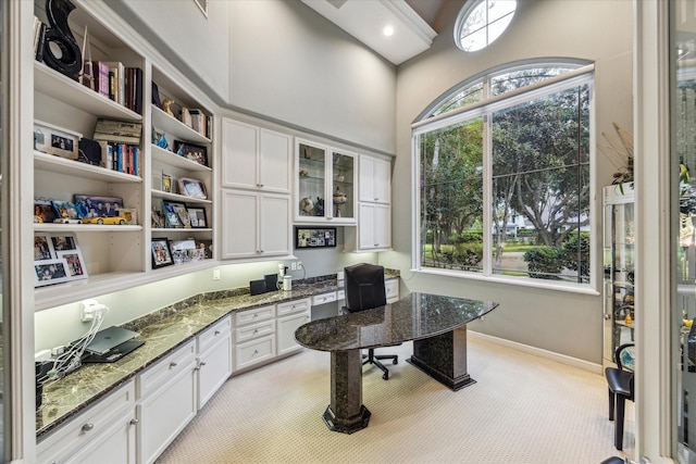 home office with built in study area and baseboards