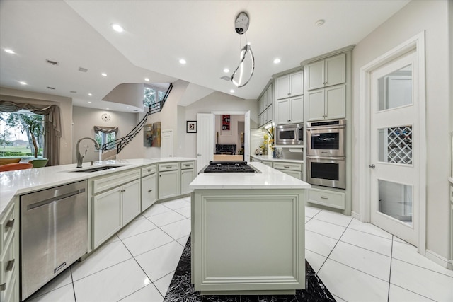 kitchen with stainless steel appliances, light countertops, light tile patterned flooring, a sink, and a kitchen island