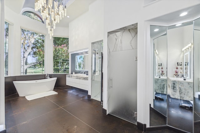 full bathroom featuring finished concrete flooring, a soaking tub, an inviting chandelier, vanity, and recessed lighting