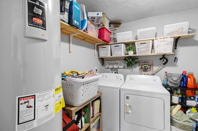 laundry area with a textured ceiling, independent washer and dryer, and water heater