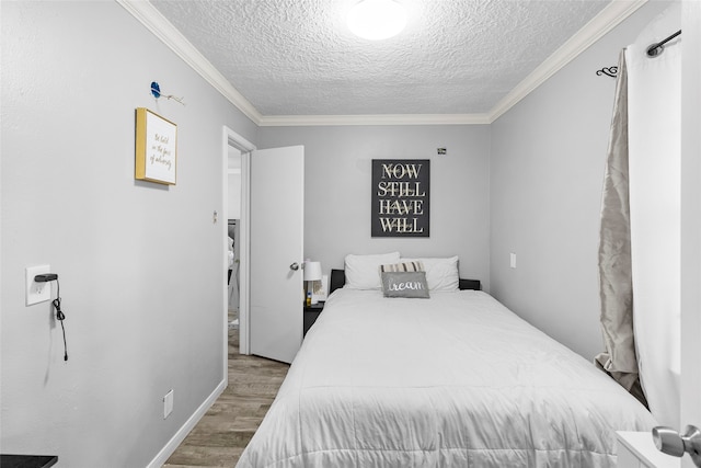 bedroom with ornamental molding, a textured ceiling, and light hardwood / wood-style flooring