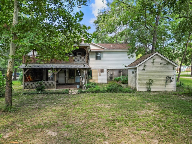 rear view of house featuring an outbuilding, a yard, and a wooden deck