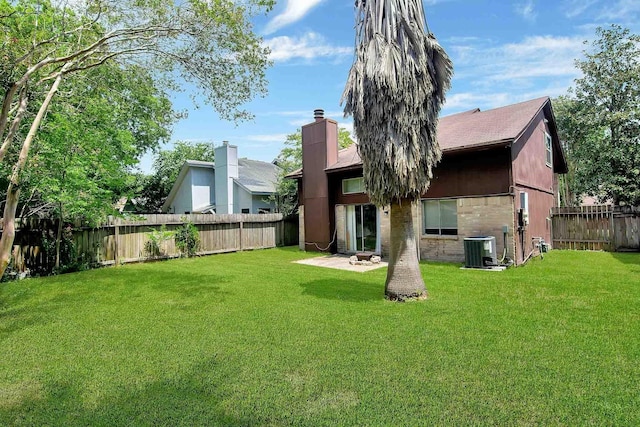 back of property featuring central AC unit and a yard