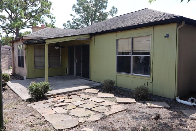 rear view of property featuring ceiling fan and a patio