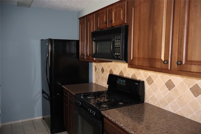 kitchen featuring black appliances, backsplash, light tile patterned floors, and a textured ceiling