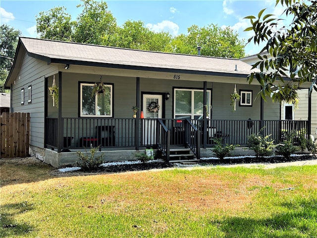 ranch-style house with a front yard and a porch