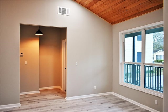 spare room with wooden ceiling, vaulted ceiling, a healthy amount of sunlight, and light wood-type flooring