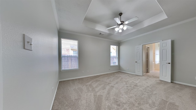 unfurnished bedroom featuring ceiling fan, a tray ceiling, and multiple windows