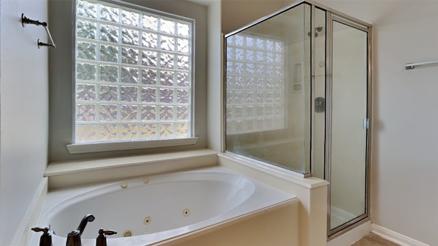 bathroom featuring independent shower and bath and a healthy amount of sunlight