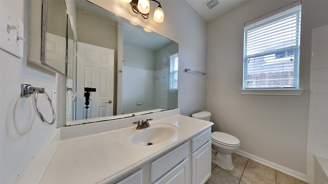 bathroom featuring tiled shower, tile patterned flooring, vanity, and toilet