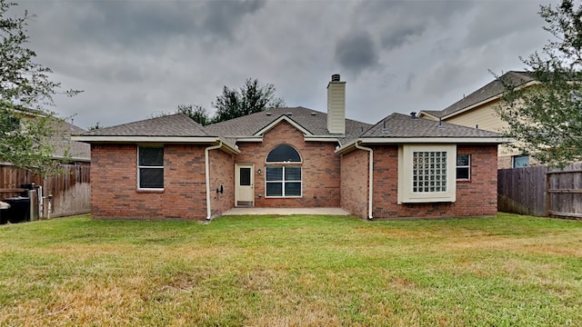 back of property featuring a lawn and a patio