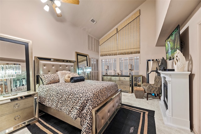 carpeted bedroom featuring high vaulted ceiling and ceiling fan