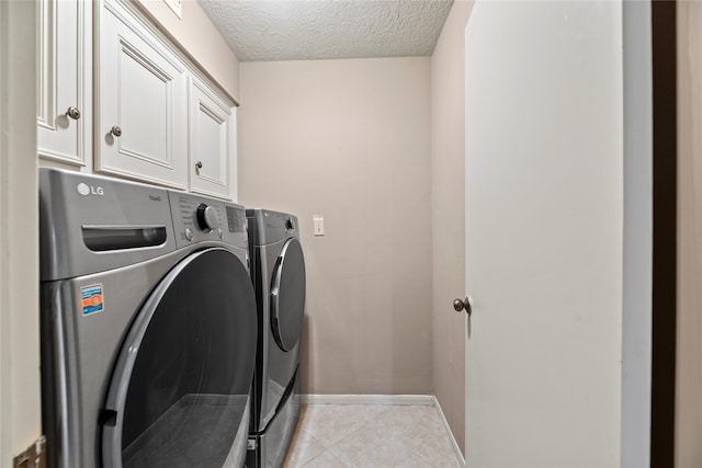 washroom featuring washer and dryer, cabinets, and a textured ceiling